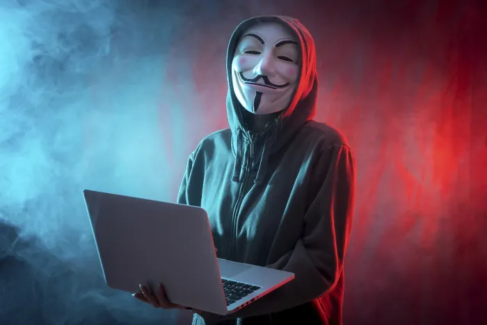 Gerahmter Druck : Ein Hacker mit anonymer Maske, bei dem ein Computer und ein Hintergrund aus Rauch und farbigen LED-Lampen zu sehen sind. Gerahmter Druck : Ein Hacker mit anonymer Maske, bei dem ein Computer und ein Hintergrund aus Rauch und farbigen LED-Lampen zu sehen sind.