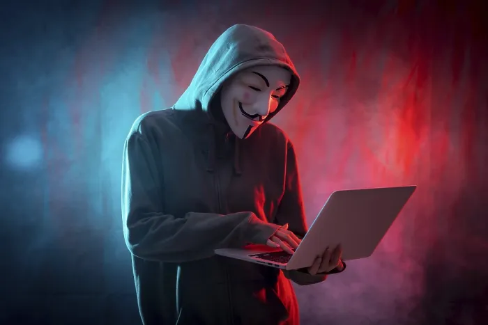 Gerahmter Druck : Ein Hacker mit anonymer Maske, mit einem Computer und einem Hintergrund aus Rauch und farbigen LED's. Gerahmter Druck : Ein Hacker mit anonymer Maske, mit einem Computer und einem Hintergrund aus Rauch und farbigen LED's.