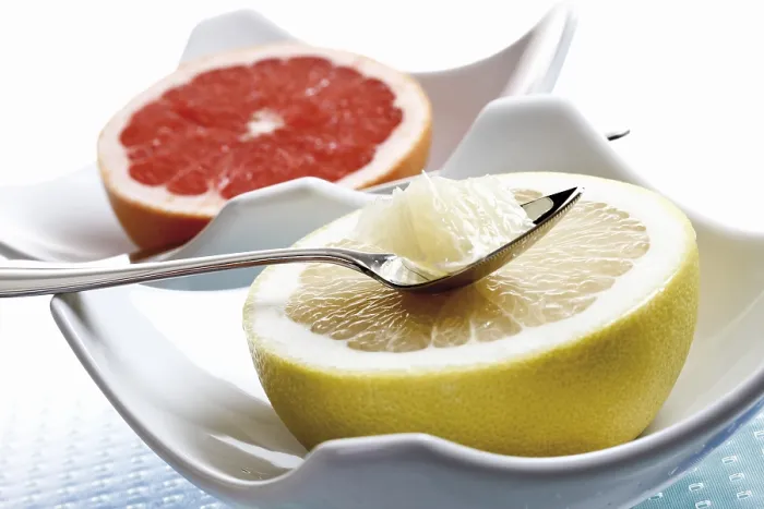 Gerahmter Druck : Die Hälfte einer Grapefruit und eine Rubingrapefruit in Porzellanbechern. Gerahmter Druck : Die Hälfte einer Grapefruit und eine Rubingrapefruit in Porzellanbechern.