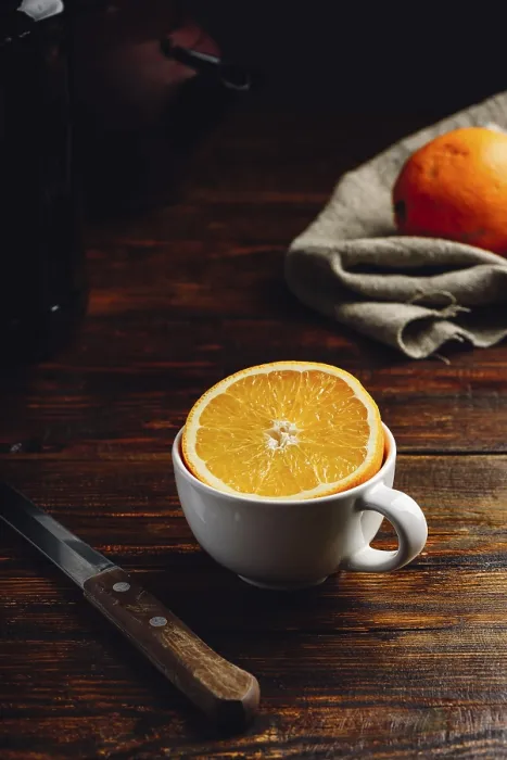 Gerahmter Druck : Die Hälfte einer Orange in einem weißen Teller über einem rustikalen Tisch. Gerahmter Druck : Die Hälfte einer Orange in einem weißen Teller über einem rustikalen Tisch.