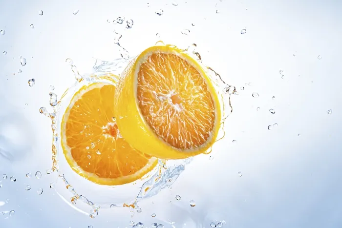 Gerahmter Druck : Zwei Hälften von Orangen fallen in Wasser. Gerahmter Druck : Zwei Hälften von Orangen fallen in Wasser.