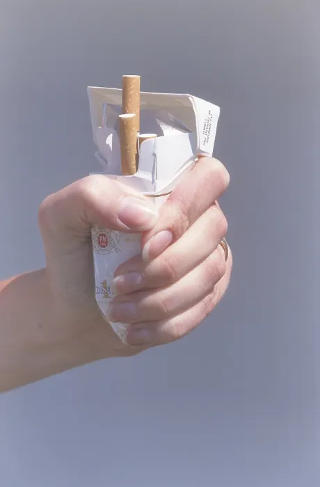 Gerahmter Druck : Eine Hand, die eine Packung Zigaretten zerdrückt. Gerahmter Druck : Eine Hand, die eine Packung Zigaretten zerdrückt.