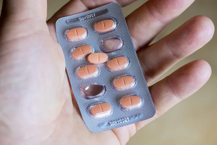Gerahmter Druck : Hand hält eine Blisterpack mit Tabletten. Gerahmter Druck : Hand hält eine Blisterpack mit Tabletten.