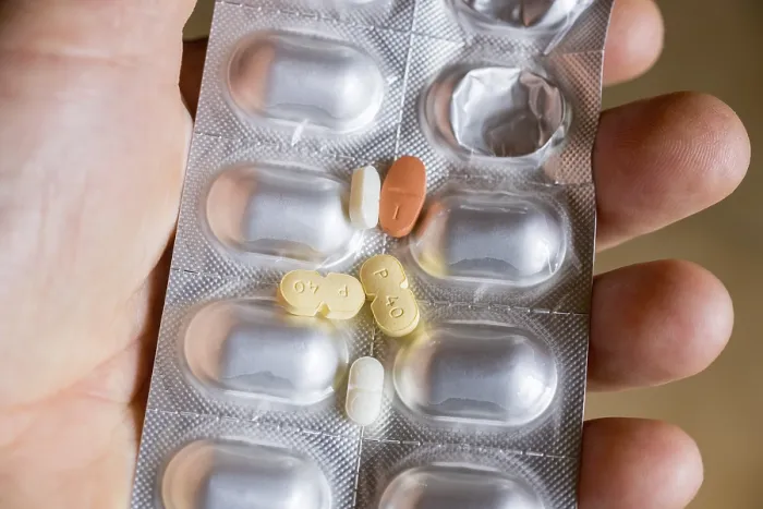Gerahmter Druck : Hand hält eine Blisterpack mit Tabletten. Gerahmter Druck : Hand hält eine Blisterpack mit Tabletten.