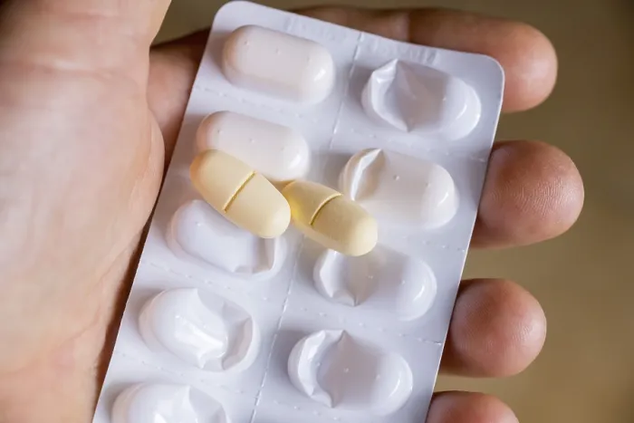 Gerahmter Druck : Eine Hand hält ein Blisterpäckchen mit Tabletten. Gerahmter Druck : Eine Hand hält ein Blisterpäckchen mit Tabletten.