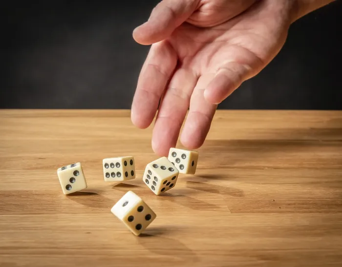 Gerahmter Druck : Würfel werfend in der Hand vor einem dunklen Hintergrund. Gerahmter Druck : Würfel werfend in der Hand vor einem dunklen Hintergrund.