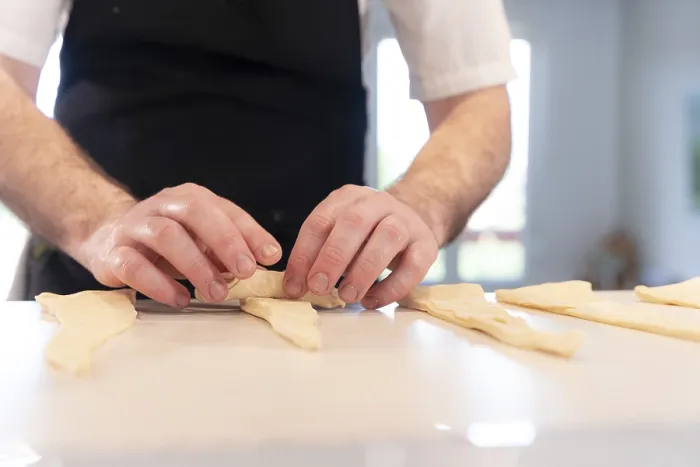 Gerahmter Druck : Hände eines Mannes, der Croissants backt. Gerahmter Druck : Hände eines Mannes, der Croissants backt.