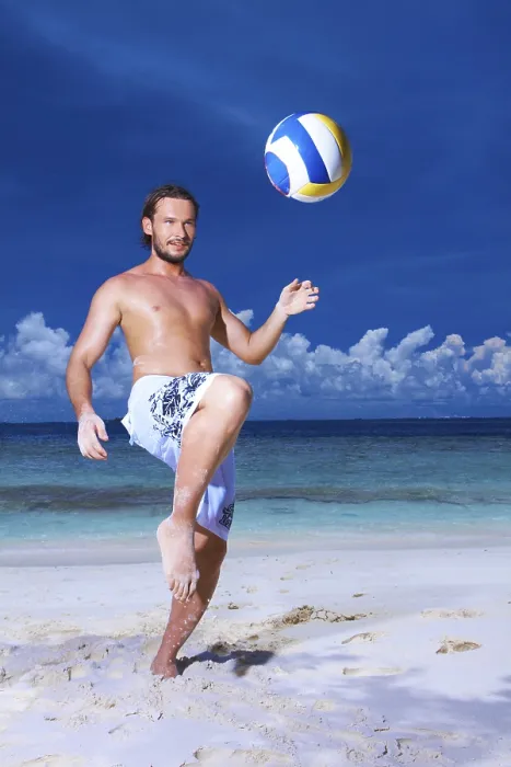 Gerahmter Druck : Ein attraktiver Mann spielt am Strand. Gerahmter Druck : Ein attraktiver Mann spielt am Strand.