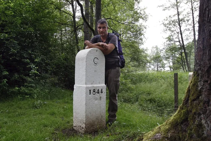 Gerahmter Druck : Wanderer am Grenzstein, Mann mit Rucksack. Gerahmter Druck : Wanderer am Grenzstein, Mann mit Rucksack.