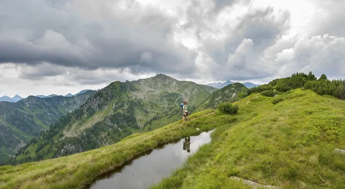 Gerahmter Druck : Wanderer wird in einem kleinen See reflektiert. Gerahmter Druck : Wanderer wird in einem kleinen See reflektiert.