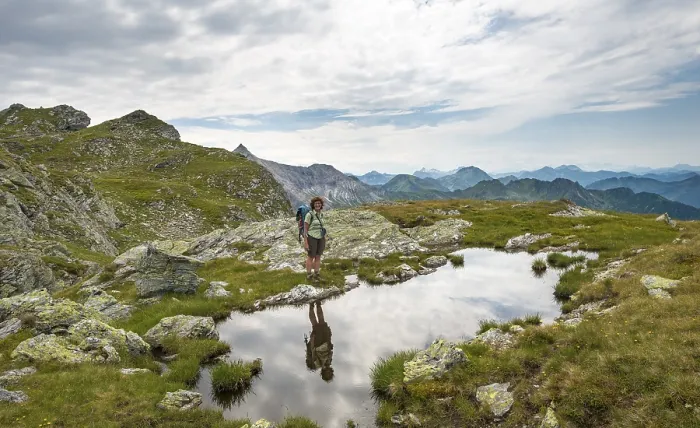 Gerahmter Druck : Wanderer wird in einem kleinen See gespiegelt. Gerahmter Druck : Wanderer wird in einem kleinen See gespiegelt.