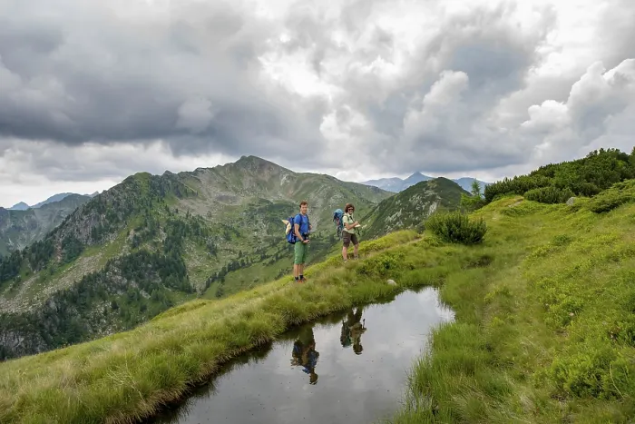 Gerahmter Druck : Wanderer werden in einem kleinen See gespiegelt. Gerahmter Druck : Wanderer werden in einem kleinen See gespiegelt.