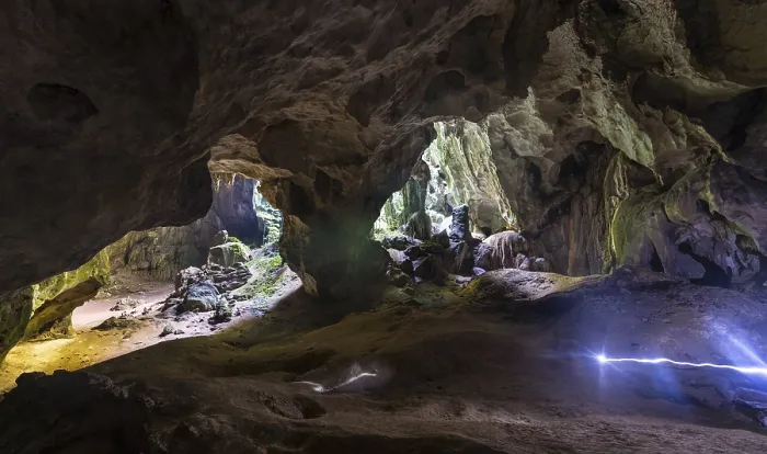 Gerahmter Druck : Wanderer gehen durch eine große Höhle. Gerahmter Druck : Wanderer gehen durch eine große Höhle.
