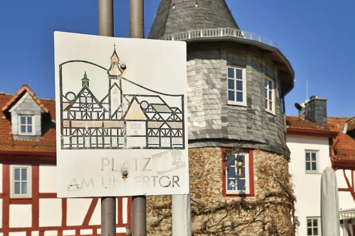 Gerahmter Druck : Hofheim, Deutschland, März 2021: Straßenschild für den alten historischen Platz namens Platz am Untertor an der alten Stadtmauer von Hofheim. Gerahmter Druck : Hofheim, Deutschland, März 2021: Straßenschild für den alten historischen Platz namens Platz am Untertor an der alten Stadtmauer von Hofheim.