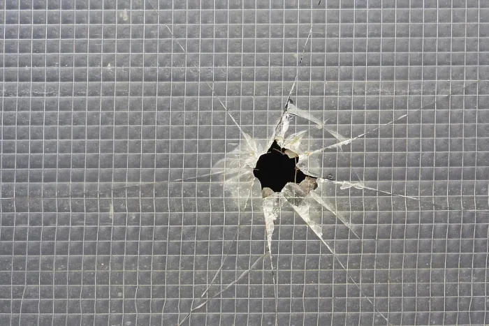 Gerahmter Druck : Ein Loch in einem zerstörten Fenster. Gerahmter Druck : Ein Loch in einem zerstörten Fenster.