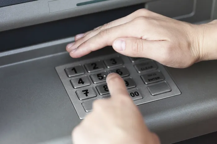 Gerahmter Druck : Menschliche Hand gibt PIN-Code in Geldautomaten ein. Gerahmter Druck : Menschliche Hand gibt PIN-Code in Geldautomaten ein.