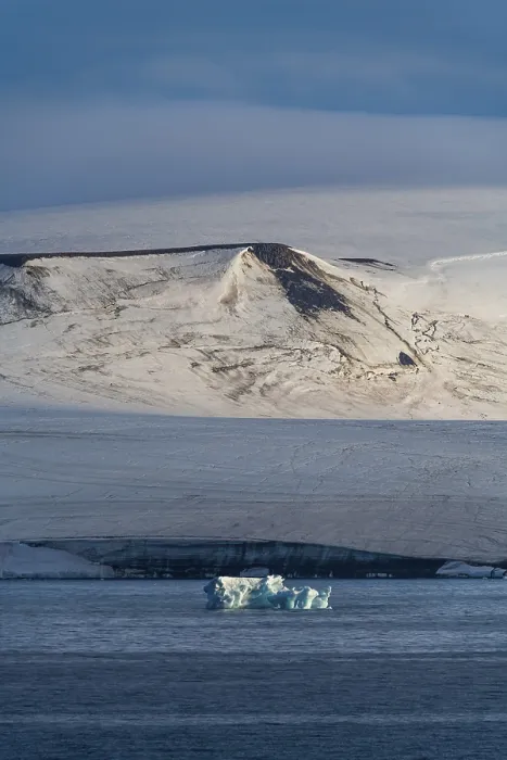 Gerahmter Druck : Ein Eisberg schwebt vor den flachen Tafelbergen, die mit Eis bedeckt sind. Gerahmter Druck : Ein Eisberg schwebt vor den flachen Tafelbergen, die mit Eis bedeckt sind.