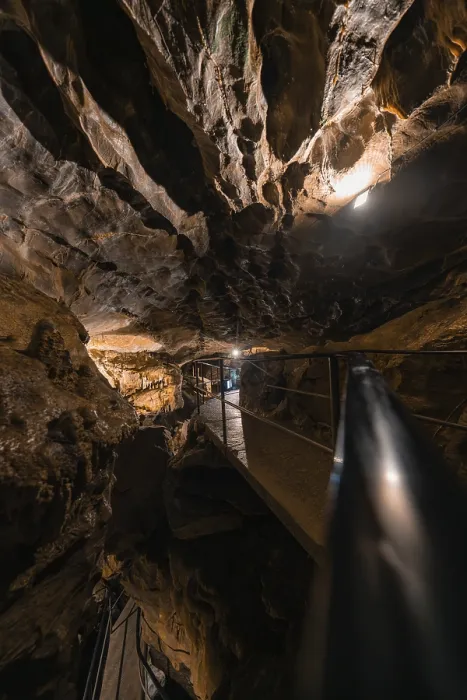 Gerahmter Druck : Illuminierter Pfad in einer Höhle, umgeben von Felsen und Dunkelheit. Gerahmter Druck : Illuminierter Pfad in einer Höhle, umgeben von Felsen und Dunkelheit.