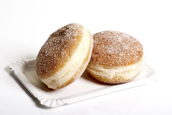 Gerahmter Druck : Zwei Mürbeteigkrapfen auf einem Papierplatten. Gerahmter Druck : Zwei Mürbeteigkrapfen auf einem Papierplatten.