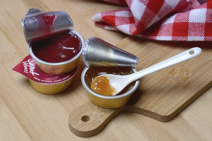 Gerahmter Druck : Marmelade in Portionspack mit Löffel, Marmelade. Gerahmter Druck : Marmelade in Portionspack mit Löffel, Marmelade.