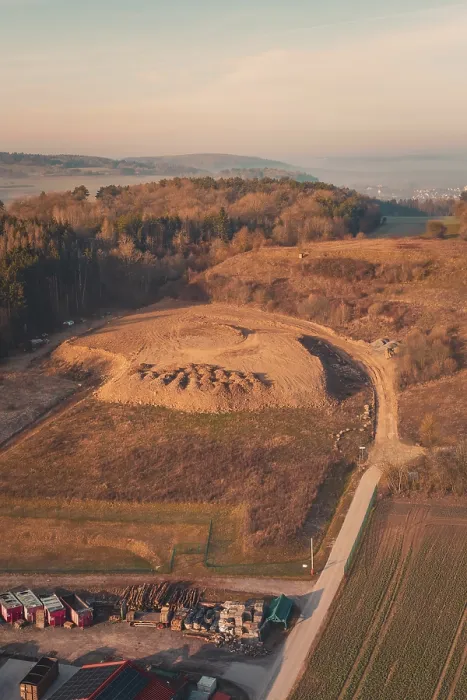 Gerahmter Druck : Landschaft mit einem großen Hügel, umgeben von Bäumen und Feldern bei Sonnenaufgang. Gerahmter Druck : Landschaft mit einem großen Hügel, umgeben von Bäumen und Feldern bei Sonnenaufgang.