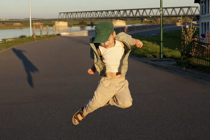 Gerahmter Druck : Kleiner Junge springt mit seinem Schatten. Gerahmter Druck : Kleiner Junge springt mit seinem Schatten.