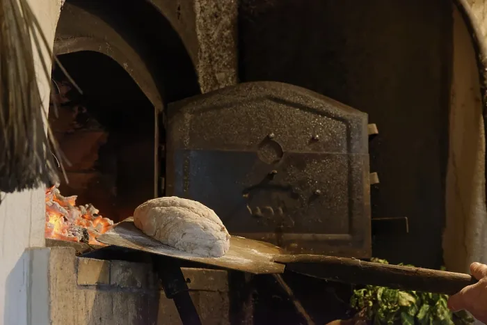 Gerahmter Druck : Brot wird in den Steinofen gelegt. Gerahmter Druck : Brot wird in den Steinofen gelegt.