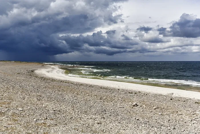 Gerahmter Druck : Ein einsamer Kieselstrand, dramatische Sturmwolken.