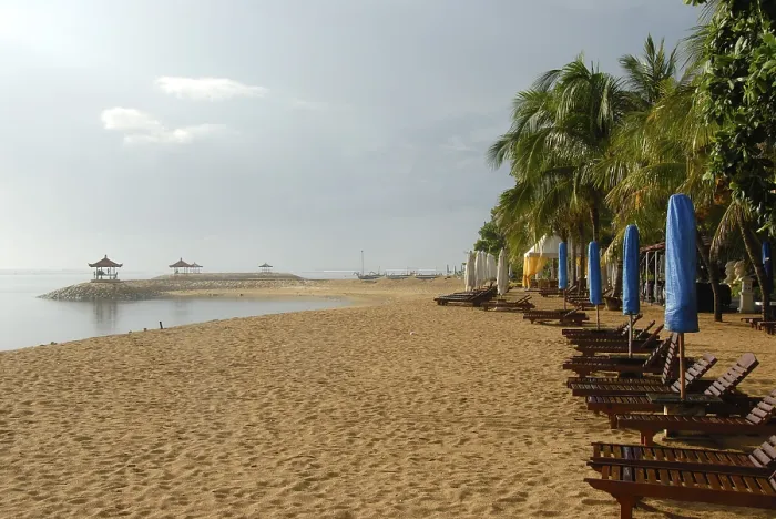 Gerahmter Druck : Langer Sandstrand mit Liegestühlen.