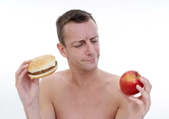 Gerahmter Druck : Mann mit Burger und Apfel. Gerahmter Druck : Mann mit Burger und Apfel.