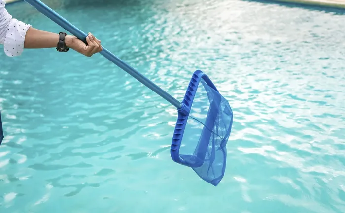 Gerahmter Druck : Ein Mann reinigt den Pool mit Blattfeger. Gerahmter Druck : Ein Mann reinigt den Pool mit Blattfeger.