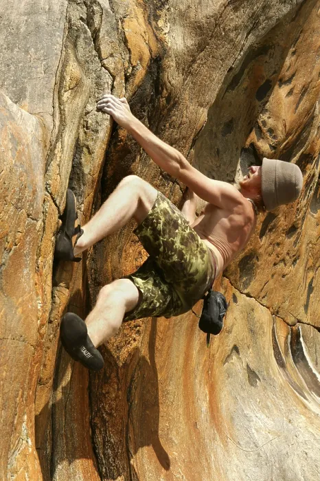 Gerahmter Druck : Ein Mann klettert einen Felsen. Gerahmter Druck : Ein Mann klettert einen Felsen.