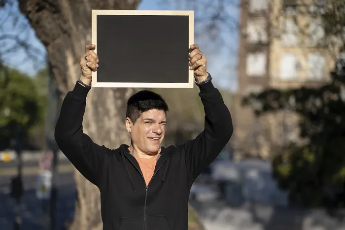 Gerahmter Druck : Ein Mann hält ein schwarzes Poster ohne Text.