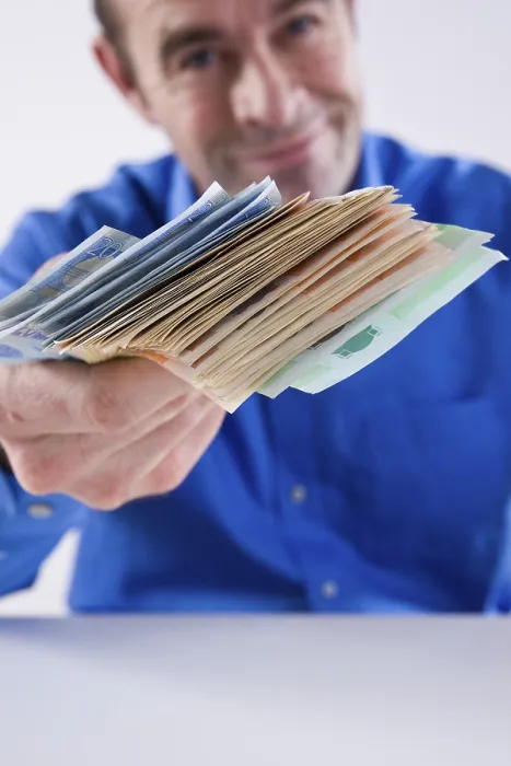 Gerahmter Druck : Ein Mann hält ein Bündel Banknoten. Gerahmter Druck : Ein Mann hält ein Bündel Banknoten.