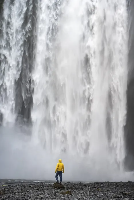 Gerahmter Druck : Ein Mann vor einem großen Wasserfall. Gerahmter Druck : Ein Mann vor einem großen Wasserfall.