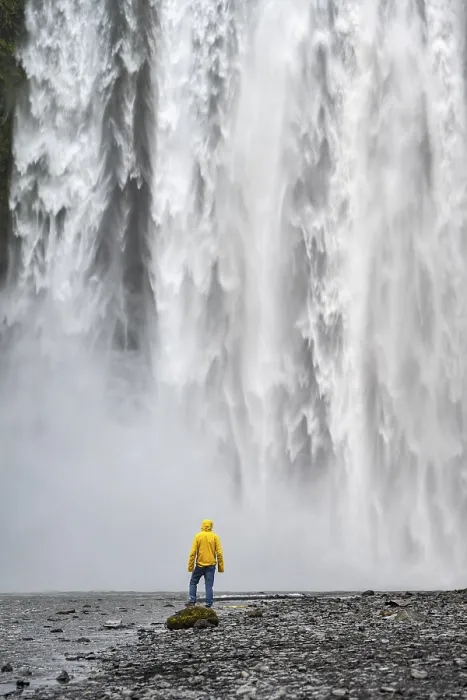 Gerahmter Druck : Ein Mann vor einem großen Wasserfall. Gerahmter Druck : Ein Mann vor einem großen Wasserfall.