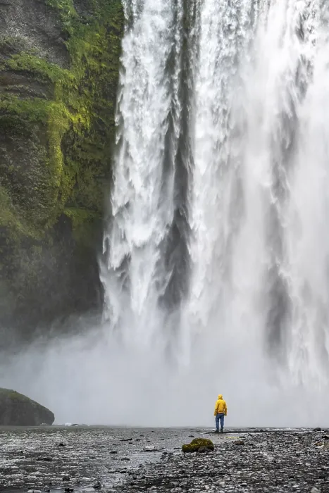 Gerahmter Druck : Ein Mann vor einem großen Wasserfall. Gerahmter Druck : Ein Mann vor einem großen Wasserfall.