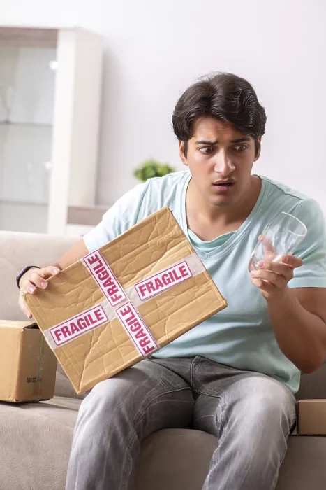 Gerahmter Druck : Ein Mann öffnet ein zerbrechliches Paket, das er im Internet bestellt hat. Gerahmter Druck : Ein Mann öffnet ein zerbrechliches Paket, das er im Internet bestellt hat.
