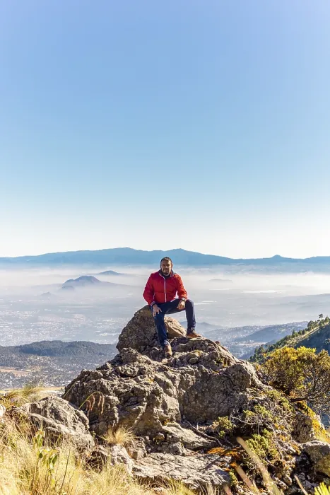 Gerahmter Druck : Ein Mann in einem roten Jacket sitzt auf einem Felsen. Gerahmter Druck : Ein Mann in einem roten Jacket sitzt auf einem Felsen.