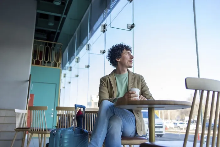 Gerahmter Druck : Ein Mann sitzt an einem Café-Tisch mit Kaffee. Gerahmter Druck : Ein Mann sitzt an einem Café-Tisch mit Kaffee.