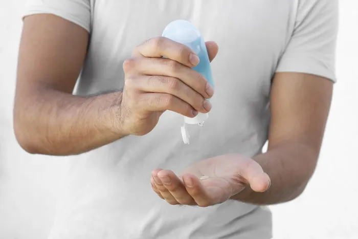 Gerahmter Druck : Ein Mann verwendet Hydroalkoholgel. Gerahmter Druck : Ein Mann verwendet Hydroalkoholgel.