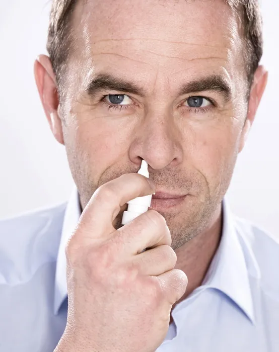 Gerahmter Druck : Ein Mann benutzt Nasenspray. Gerahmter Druck : Ein Mann benutzt Nasenspray.