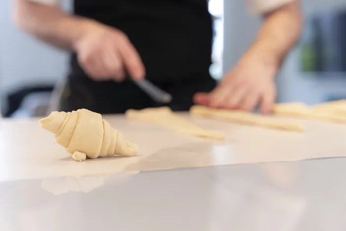 Gerahmter Druck : Ein Detail von den Händen eines Mannes, der Croissants backt. Gerahmter Druck : Ein Detail von den Händen eines Mannes, der Croissants backt.