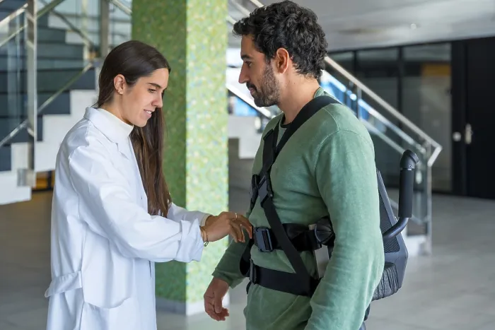Gerahmter Druck : Mechanischer Exoskelett, weibliche Physiotherapeutin Doktor klebt Bandagen auf einen behinderten Menschen mit Roboter-Skelett. Gerahmter Druck : Mechanischer Exoskelett, weibliche Physiotherapeutin Doktor klebt Bandagen auf einen behinderten Menschen mit Roboter-Skelett.