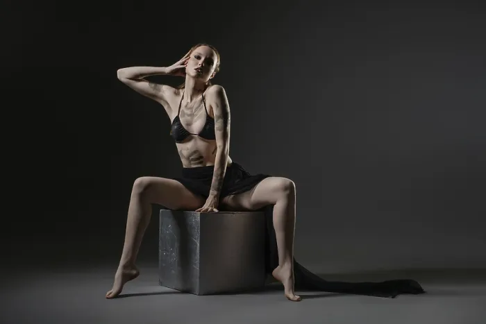 Gerahmter Druck : Das Modell präsentiert eine elegante Pose auf einem Würfel. Gerahmter Druck : Das Modell präsentiert eine elegante Pose auf einem Würfel.