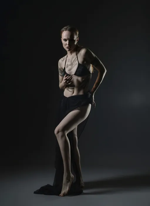 Gerahmter Druck : Ein Model steht selbstbewusst in einem dunklen Studio. Gerahmter Druck : Ein Model steht selbstbewusst in einem dunklen Studio.