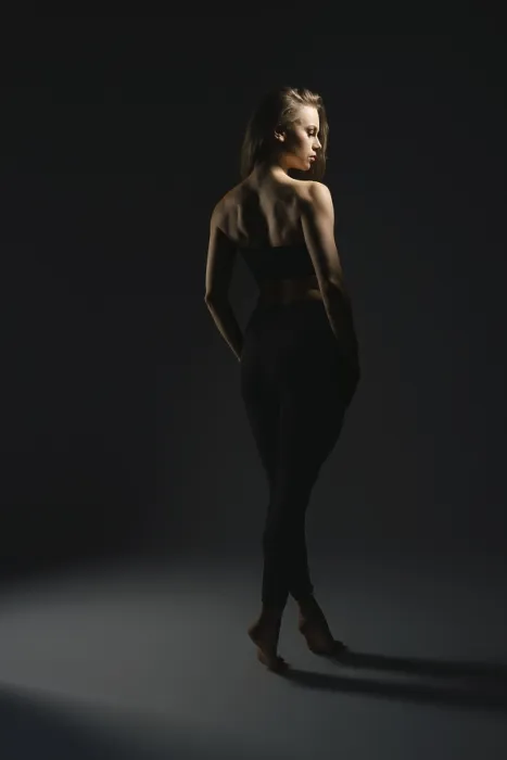 Gerahmter Druck : Ein Model steht elegant unter weichem Licht in einem dunklen Studio. Gerahmter Druck : Ein Model steht elegant unter weichem Licht in einem dunklen Studio.
