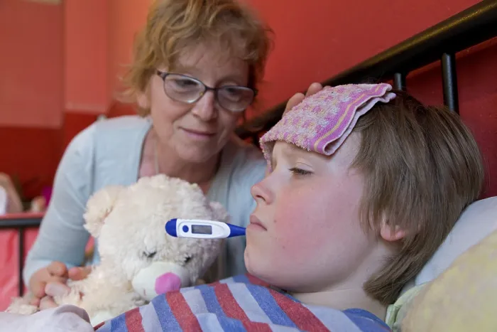 Gerahmter Druck : Die Mutter tröstet den kranken Sohn im Bett.