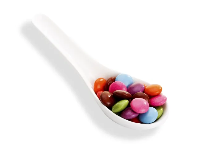 Gerahmter Druck : Bunte Smarties auf einem Löffel Gerahmter Druck : Bunte Smarties auf einem Löffel