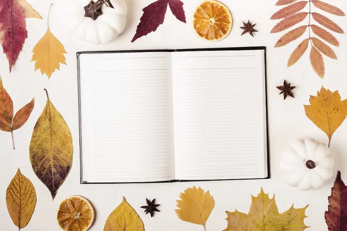 Gerahmter Druck : Notepad auf weißem Tisch mit Herbstblättern-Muster. Gerahmter Druck : Notepad auf weißem Tisch mit Herbstblättern-Muster.